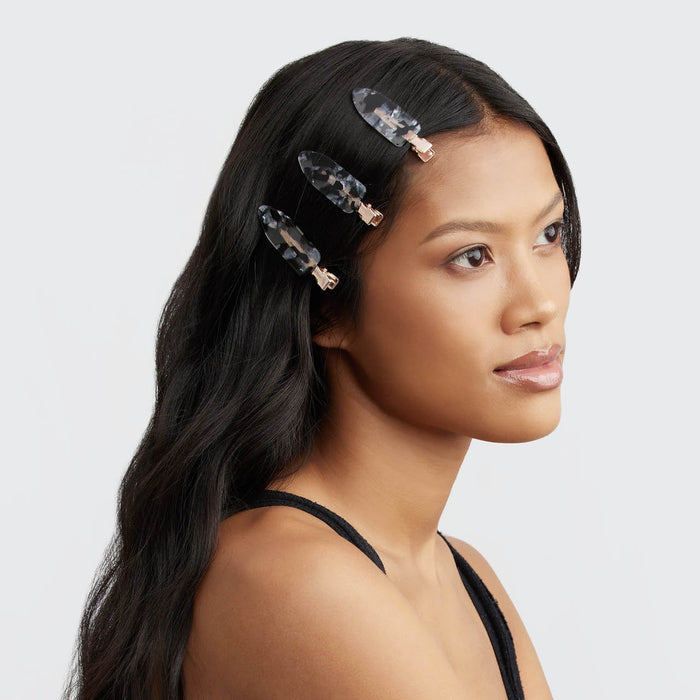 Model wearing a tortoise print Kitsch creaseless hair clip in sleek dark hair.