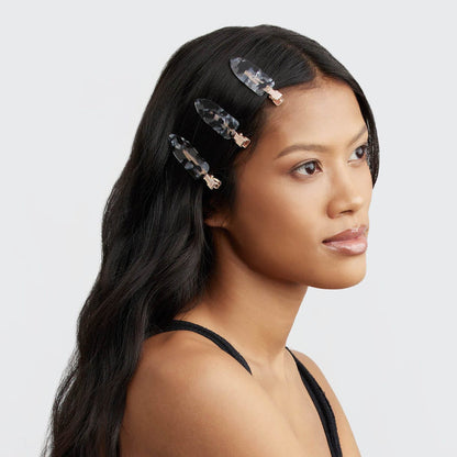 Model wearing a tortoise print Kitsch creaseless hair clip in sleek dark hair.