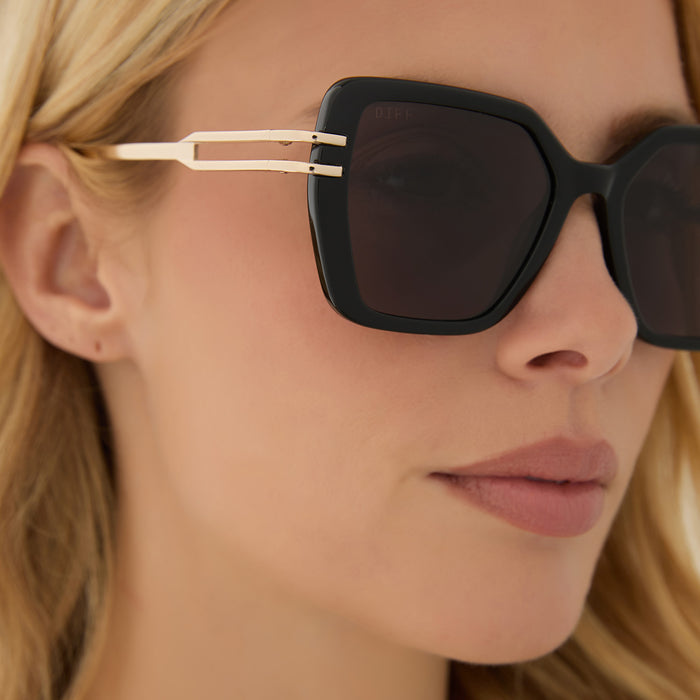 on model - blonde female wearing diff eyewear featuring the dasha square sunglasses with a black frame and grey lenses detailed view