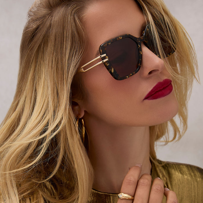 on model - female wearing diff eyewear featuring the dasha square sunglasses with a glitter gold tortoise frame and brown lenses angled view