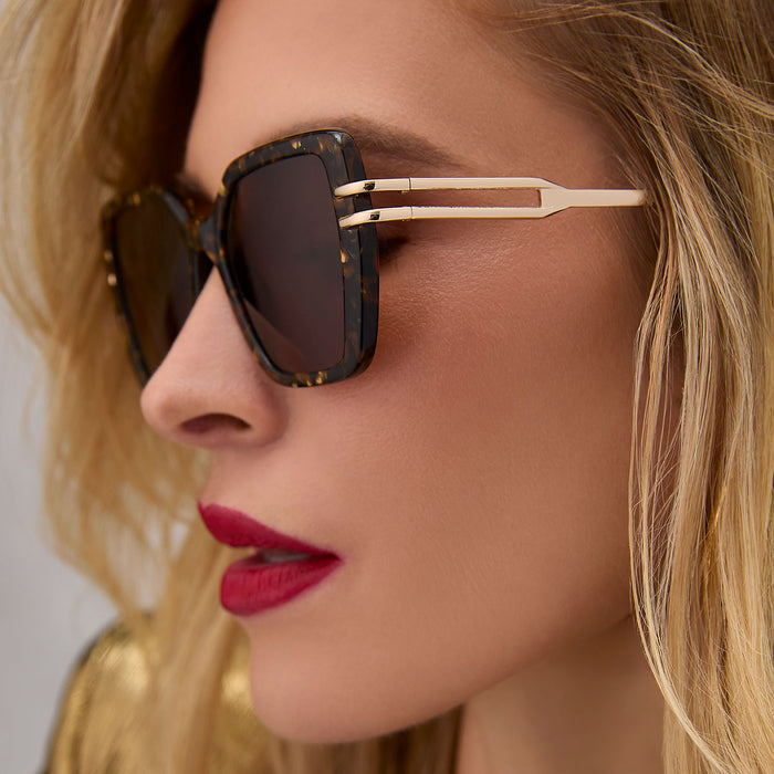 on model - female wearing diff eyewear featuring the dasha square sunglasses with a glitter gold tortoise frame and brown lenses side view