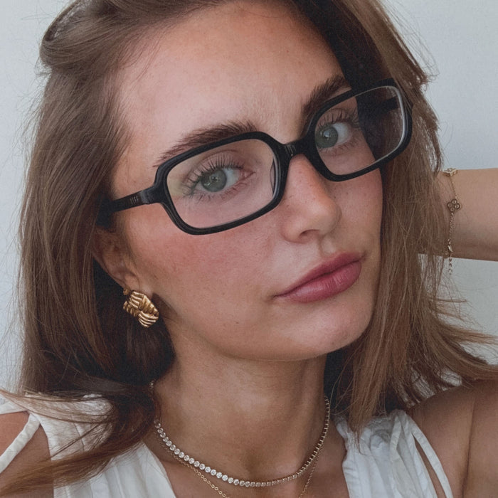on model - aspyn ovard female wearing aspyn ovard x diff eyewear featuring the elle rectangle prescription glasses with a black frame angled view