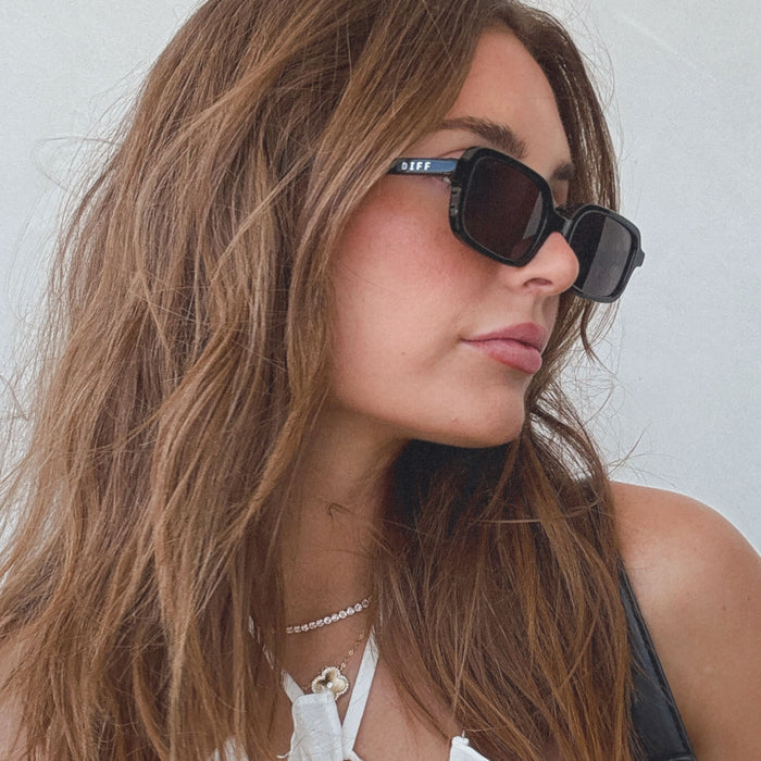 lifestyle - aspyn ovard x diff eyewear featuring the elle rectangle prescription glasses with a black frame and prescription grey lenses angled view