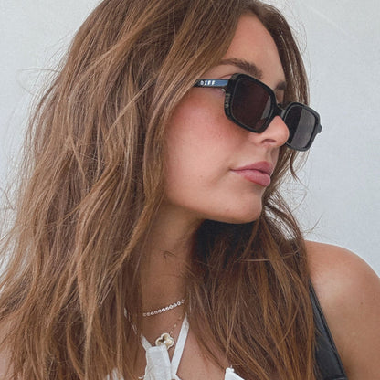 lifestyle - aspyn ovard x diff eyewear featuring the elle rectangle prescription glasses with a black frame and prescription grey lenses angled view