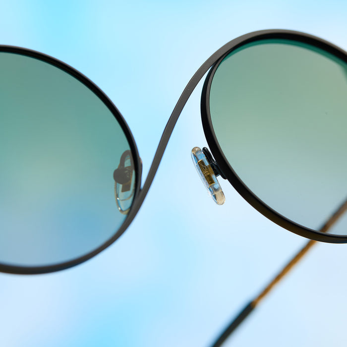 wicked x diff eyewear featuring the elphaba wire frames round sunglasses with a black frame and green lenses detailed view of nose bridge