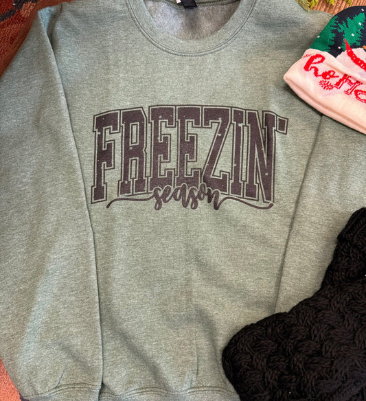 Light gray sweatshirt with large 'FREEZIN' logo and red cursive text