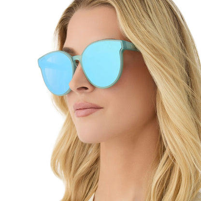 on model - female wearing diff eyewear featuring the gemma round sunglasses with a aquatic awe teal frame and aquatic awe teal mirror lenses angled view