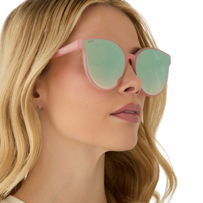 on model - female wearing diff eyewear featuring the gemma round sunglasses with a peach frame and cool matcha gradient mirror lenses angled view