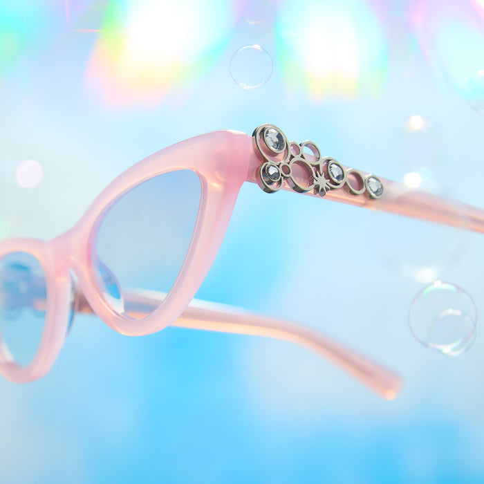 lifestyle - wicked x diff eyewear featuring the glinda upland for good cat eye sunglasses with a pink frame and pink lenses detailed view of temple