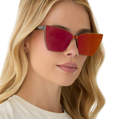 on model - female wearing diff eyewear featuring the goldie xs cat eye sunglasses with a animal print frame and red hot summer mirror lenses angled view