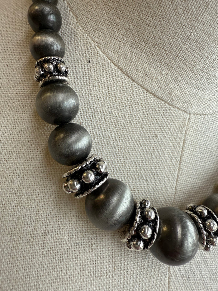 Graduated pearl necklace with dark gray beads and silver-tone filigree spacers