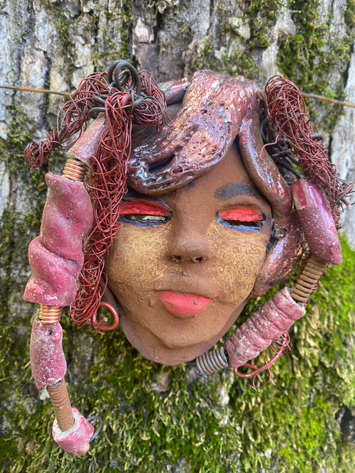 Valiza boasts an eye-catching rust brown complexion complete with rust  red lips.  At 7" x 5" and 10 ozs. she is crafted with 5 handmade, raku-fired beads. Additionally, Valiza features over 15 feet of coiled 24 and 16 gauge wire hair. If you have questions, please reach out!