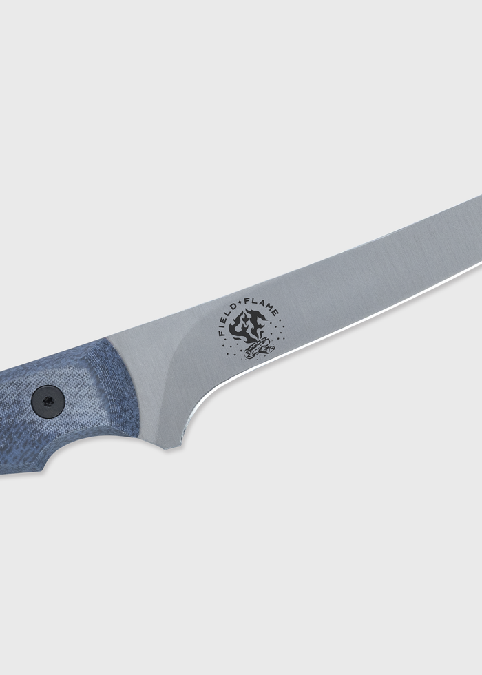 Close-up of a sleek knife with a blue handle and "Field & Flame" logo on the blade, set against a plain background.