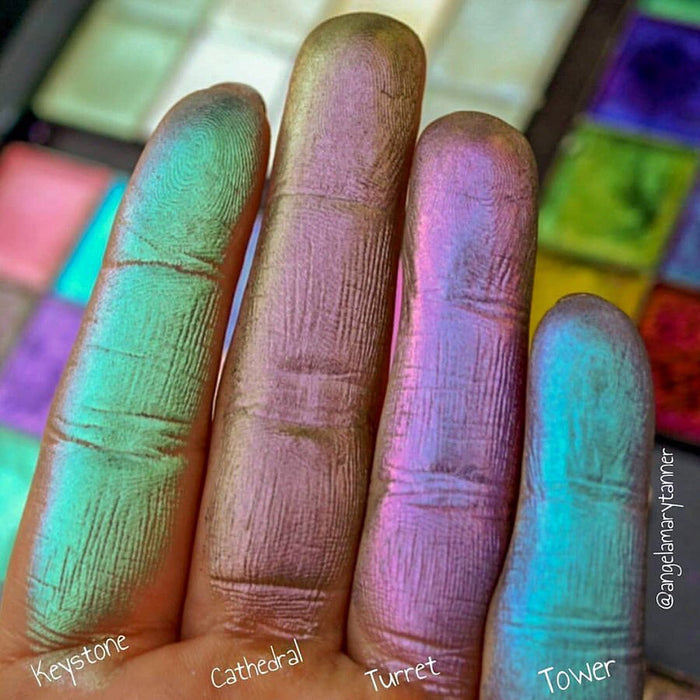 Close up finger swatches of Keystone Pastel Multichrome Eyeshadow shifts next to Tower, Cathedral, Turret