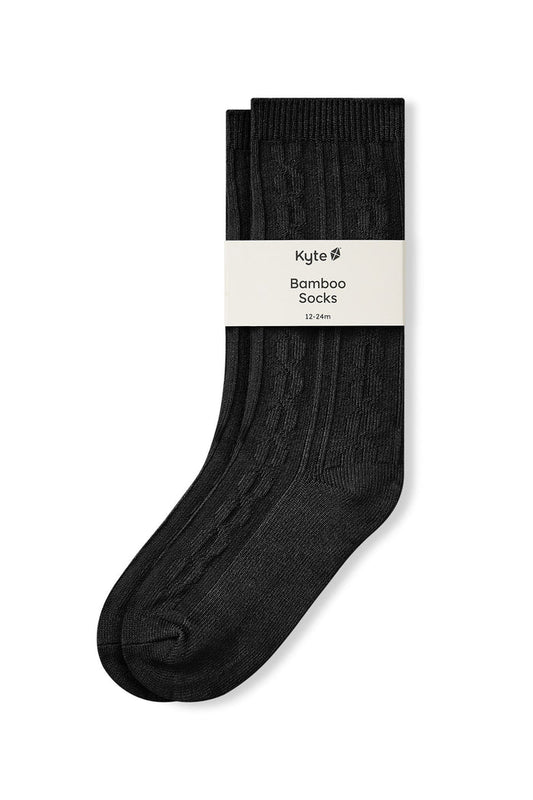 Knee high socks in midnight laying flat on a white background.