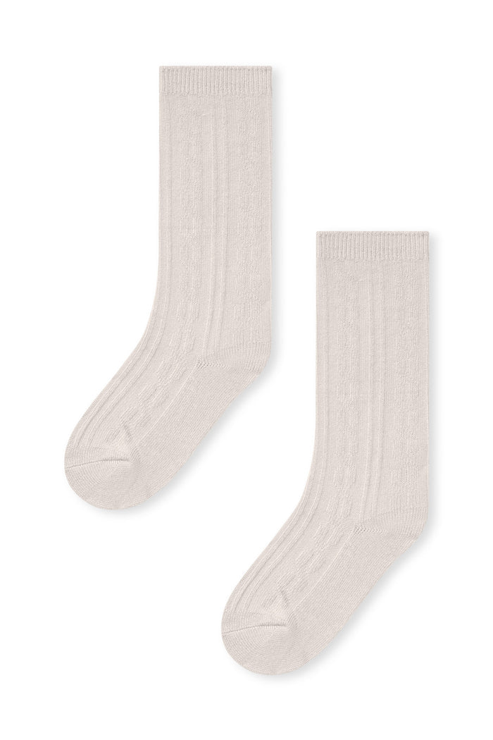 Knee high socks in oat laying flat on a white background.