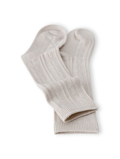 Knee high socks in oat laying flat on a white background.