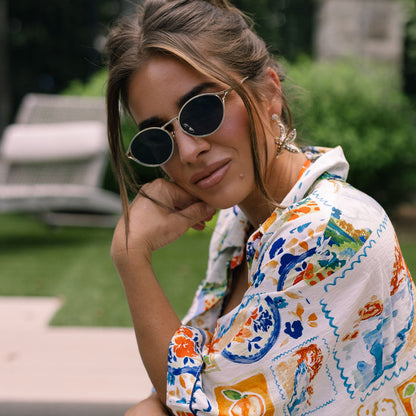 lifestyle - jessie james decker female wearing diff eyewear featuring the limoncello oval sunglasses with a gold frame and grey lenses front view