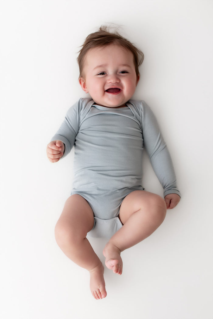 Baby wearing a light blue onesie on a white background