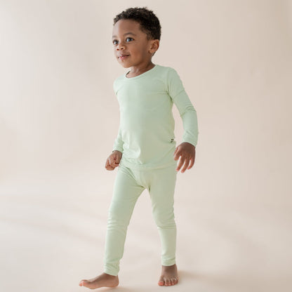 Child modeling light green long sleeve bamboo pajamas