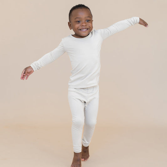 Young boy modeling an off-white long sleeve pajama set