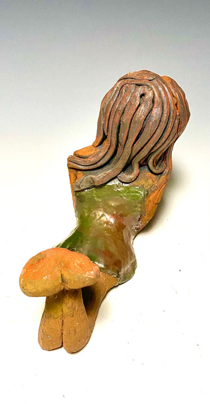 Marie waits patiently! Marie stands 6" x 3.5" x 7.5" and weighs 1.11 lbs. Marie has a lovely honey brown complexion with ruby red lips.. Her long loving arms are underneath her face as she ponders. Marie dress is a copper glazed and she has hair made of clay. Marie is bright eyed and ready to be placed in a good home.