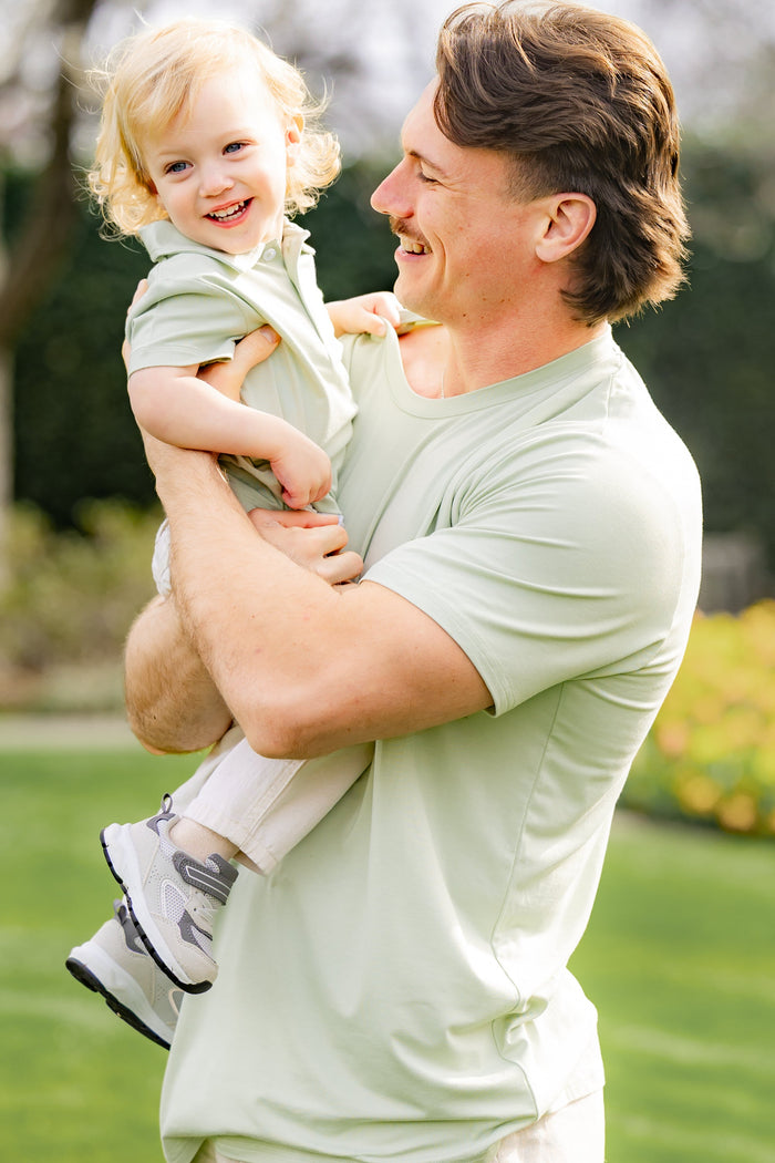 Father wearing the Men's Crew Neck in Basil holding his son who is in a matching short sleeve toddler polo