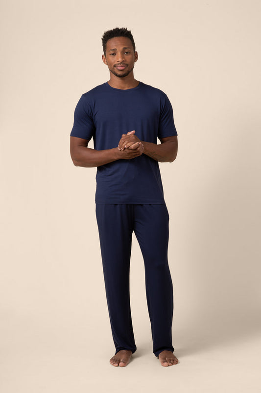 Man wearing navy blue pajamas on a beige background