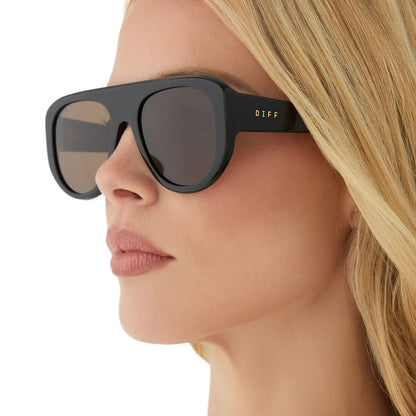 on model - female wearing diff eyewear featuring the morgan shield sunglasses with a black frame and brown lenses detailed view