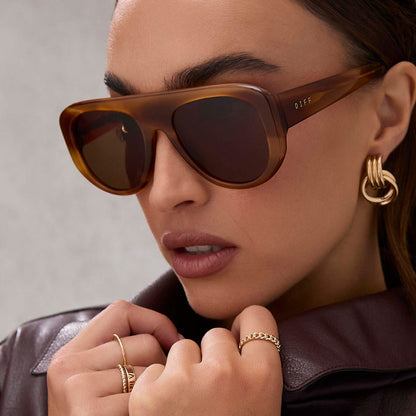on model - female wearing diff eyewear featuring the morgan shield sunglasses with a tawny tortoise frame and brown lenses angled view