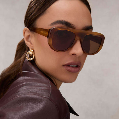on model - female wearing diff eyewear featuring the morgan shield sunglasses with a tawny tortoise frame and brown lenses angled view