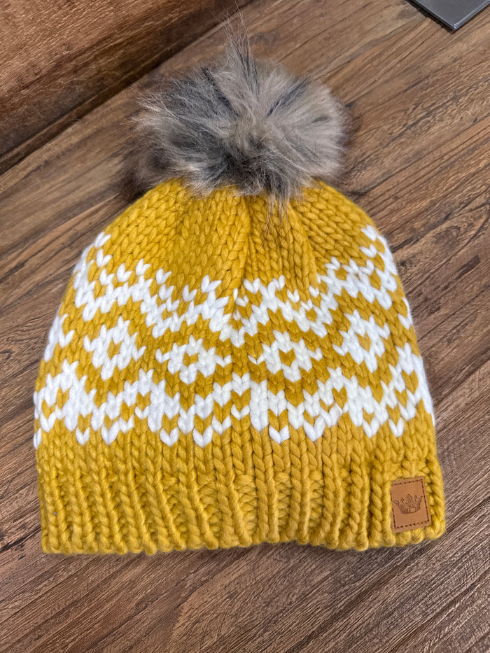 Mustard knit winter beanie with cream zigzag pattern and gray pom-pom