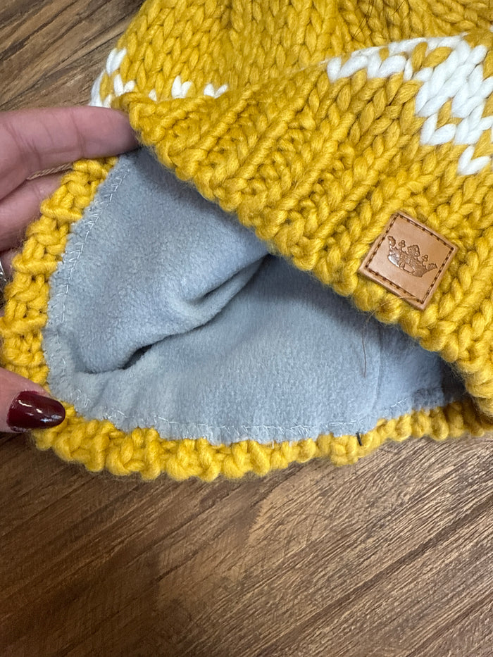 Mustard knit winter beanie with gray lining and tan brand leather patch