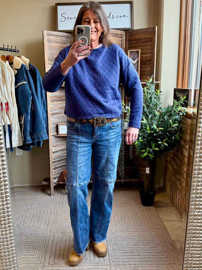 Blue quilted crewneck sweatshirt with long sleeves, side view in mirror