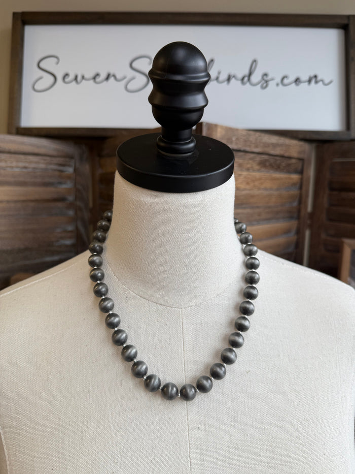 Pearl spacer beads necklace on mannequin with dark round beads
