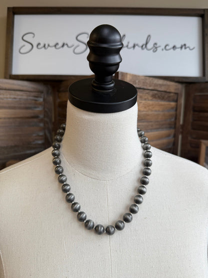 Pearl spacer beads necklace on mannequin with dark round beads