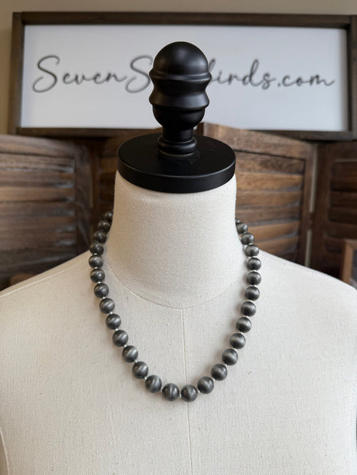 Pearl spacer beads necklace on mannequin with dark round beads