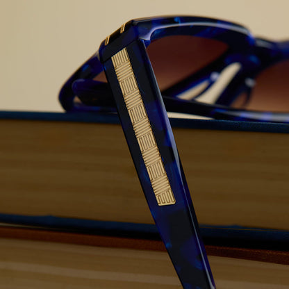 lifestyle - wicked x diff eyewear featuring the prince fiyero square sunglasses with a regal blue tortoise frame and brown gradient lenses detailed view of temple