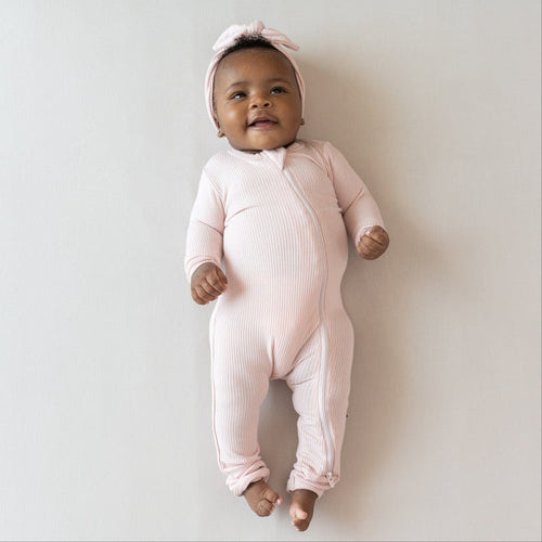 Infant wearing Kyte Baby Ribbed Zippered Romper in Blush