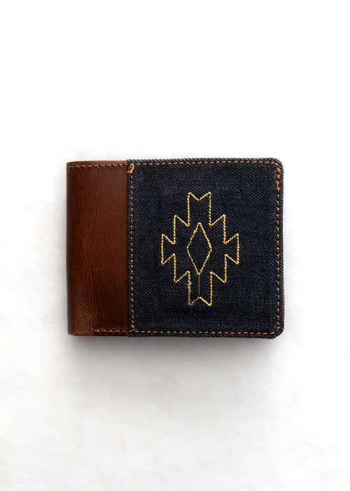 Brown leather wallet with a denim front, featuring a yellow geometric pattern. Simple and stylish design on a white background.