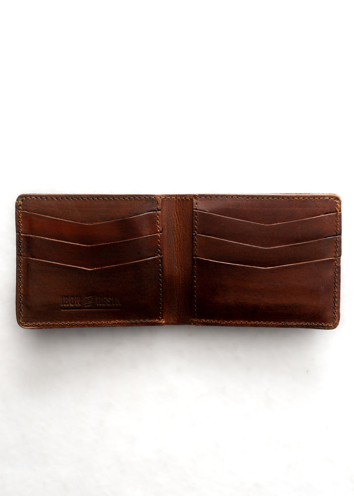 Open brown leather wallet with multiple card slots, embossed "Iron & Resin" logo, on a white background.