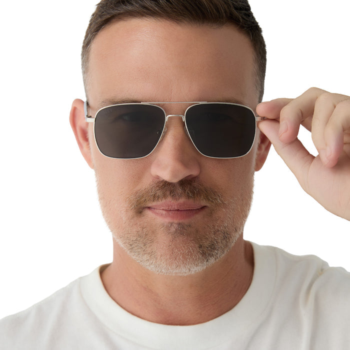 on model - male wearing yellowstone x diff eyewear featuring the rip wheeler navigator sunglasses with a silver frame and grey polarized lenses front view