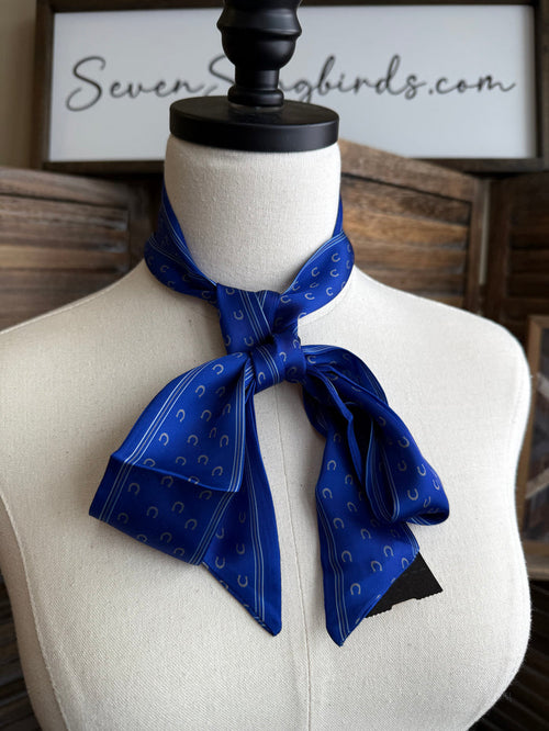 Royal blue horseshoe twilly scarf tied in a bow on a mannequin, striped ends