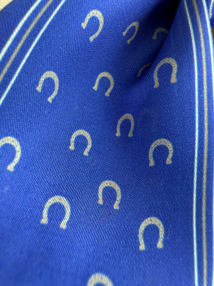 Royal blue twilly scarf with gold horseshoe pattern and thin striped edge