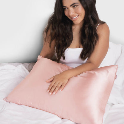 Model holding a Blush King Satin Pillowcase