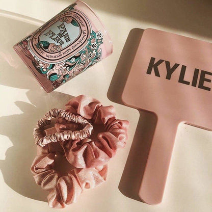 KITSCH Satin Sleep Scrunchies in Blush — lifestyle product shot of blush pink satin sleep scrunchies — silky construction prevents creasing and breakage overnight