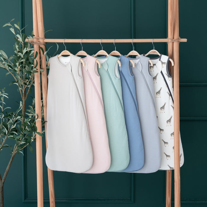 Core color Kyte Baby Sleep Bags TOG 2.5 on hangers hanging on a wooden rack