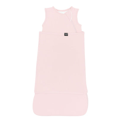 Sleep Bag Swaddler in Blush 1.0 shown swaddled with the Black Kyte Baby logo visible