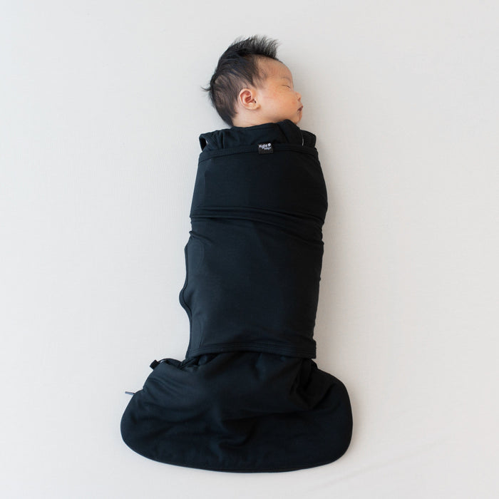 Sleeping baby swaddled in the Sleep Bag Swaddler in Midnight 1.0