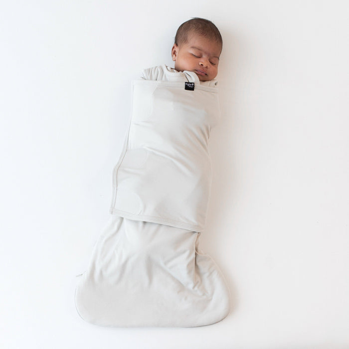 Sleeping baby swaddled in the Sleep Bag Swaddler in Oat 1.0